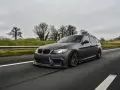 Szare BMW kombi pędzi autostradą, czuć jego prędkość.