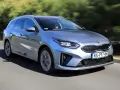 Srebrny Kia Ceed 1.6 benzyna w wersji kombi pędzi po drodze, otoczony zielenią.