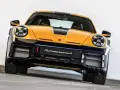 Żółto-granatowy Porsche 911 Dakar, gotowy na rajd dakar, z napisem "Sondermunsch" na zderzaku.