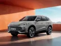 Nowy samochód MG HS Hybrid+ prezentuje się nowocześnie na tle pomarańczowej ściany i błękitnego nieba.
