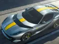 Szary Ferrari 812 Superfast z żółtymi pasami na masce i dachu, gotowy do szaleństwa na torze.