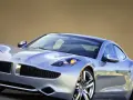 Srebrny Fisker Karma z eleganckimi liniami i sportowymi felgami, gotowy na podróż.