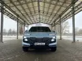 Jasny Jetour Dashing z charakterystycznym grillem i światłami LED stoi pod zadaszeniem.