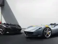 Dwa sportowe samochody Ferrari Monza SP2, jeden czarny, drugi błękitny z żółtymi pasami, prezentują swoje aerodynamiczne kształty.