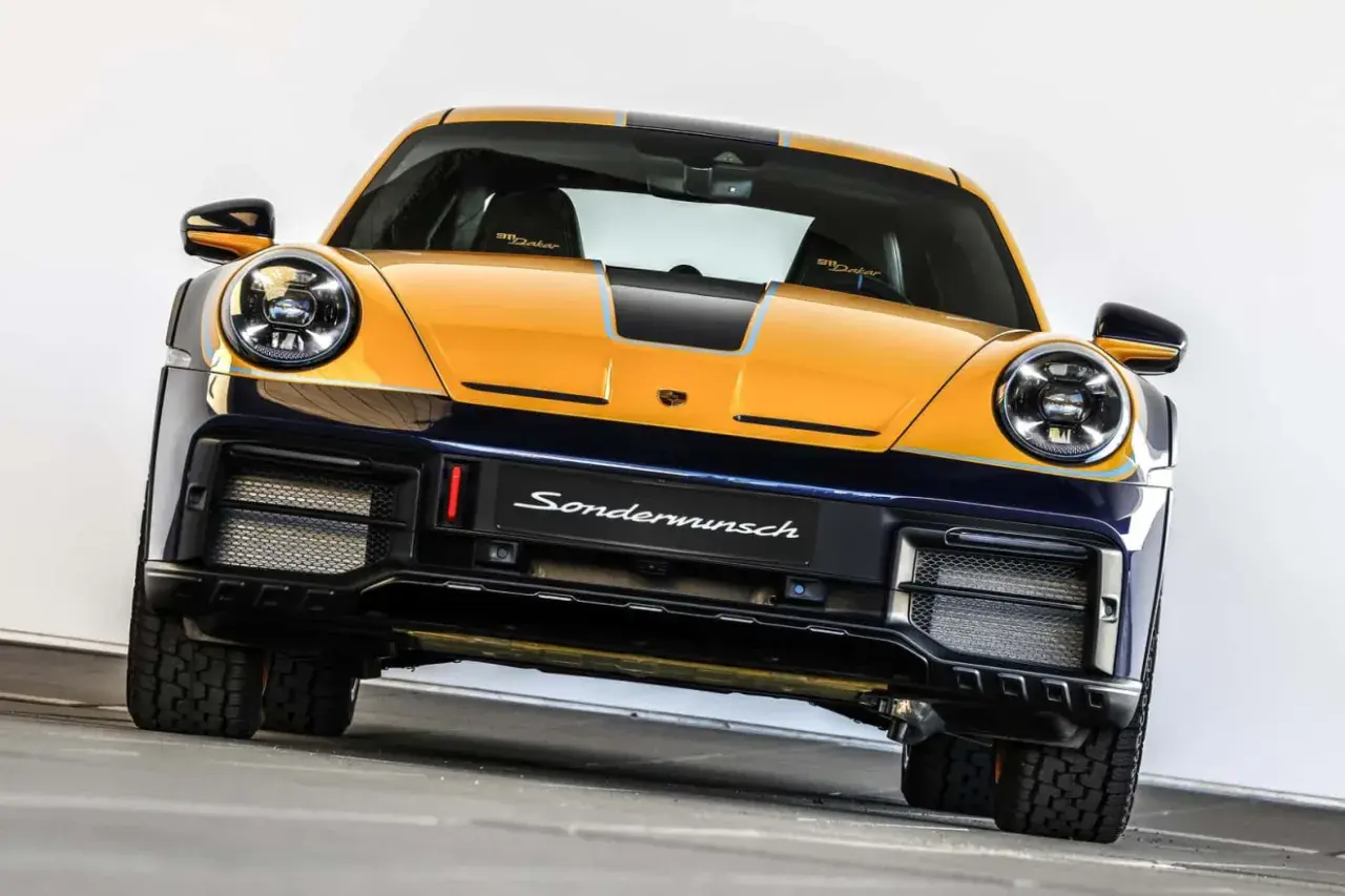 Żółto-granatowy Porsche 911 Dakar, gotowy na rajd dakar, z napisem "Sondermunsch" na zderzaku.