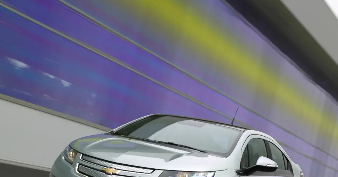 Srebrny Chevrolet Volt z nowoczesnym designem na tle tęczowej ściany.