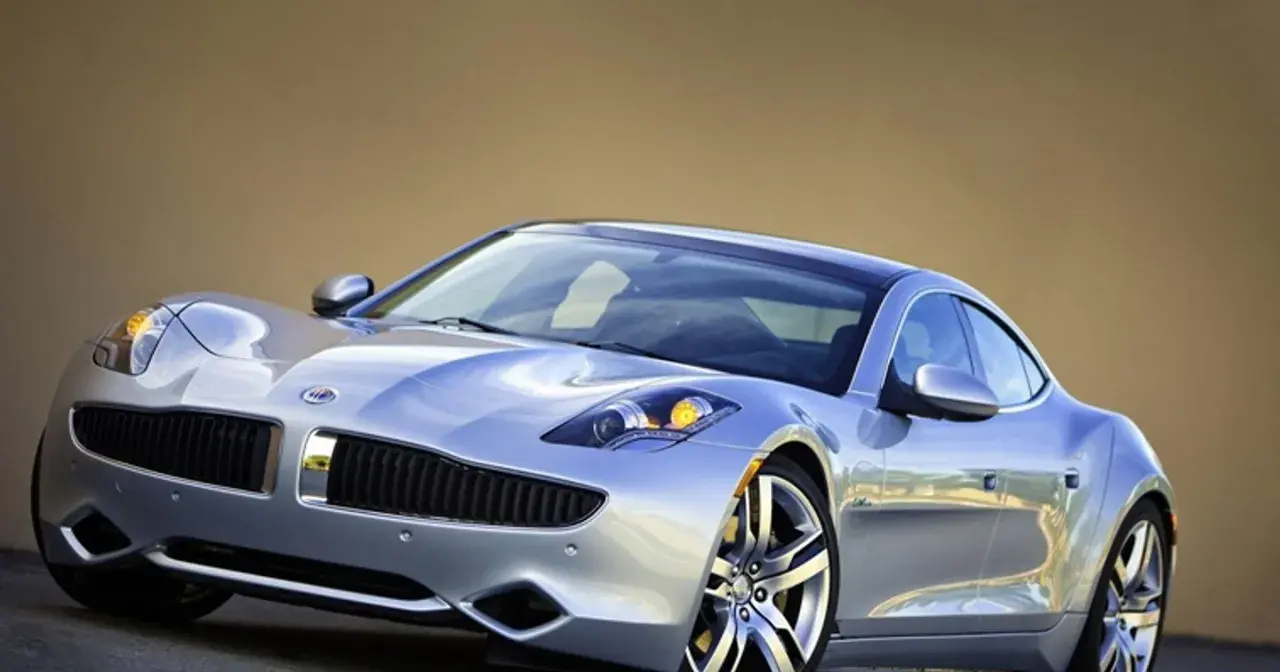 Srebrny Fisker Karma z eleganckimi liniami i sportowymi felgami, gotowy na podróż.