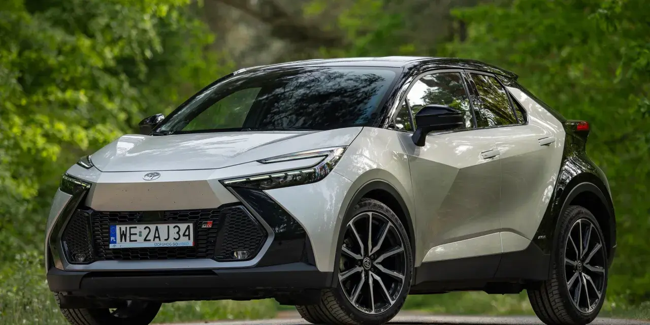 Nowa Toyota C-HR 2025 w kolorze srebrno-czarnym, zaparkowana na leśnej drodze.