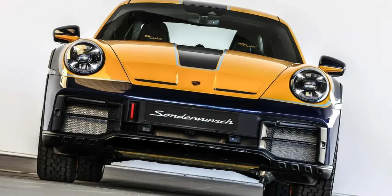 Żółto-granatowy Porsche 911 Dakar, gotowy na rajd dakar, z napisem "Sondermunsch" na zderzaku.