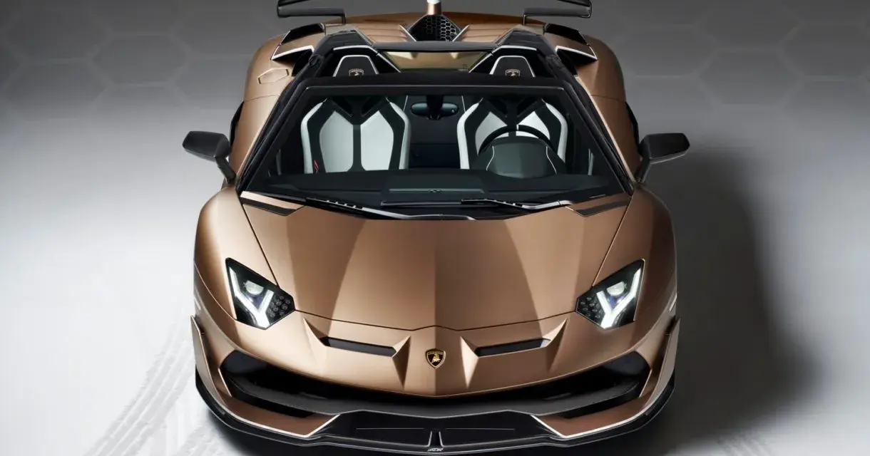 Brązowy Lamborghini Aventador SVJ z otwartym dachem, z czarnym spoilerem i białymi akcentami we wnętrzu, gotowy do jazdy.