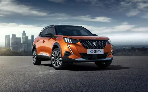 Pomarańczowy Peugeot 2008 na tle miasta. Sprawdź jego wymiary i możliwości.