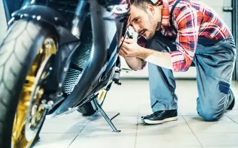 Mechanik sprawdza motocykl. Dowiedz się, ile kosztuje przegląd motocykla, zanim oddasz go do serwisu.