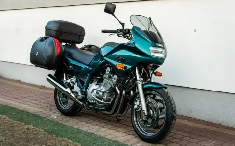 Zielony motocykl Yamaha XJ 900 z kuframi, gotowy na dalekie podróże.