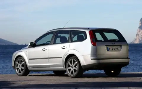 Srebrny Ford Focus MK2 1.6 benzyna kombi zaparkowany nad wodą.