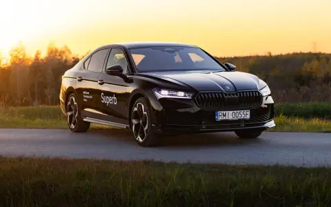 Czarny Skoda Superb 4 na tle zachodzącego słońca. Elegancki sedan z nowoczesnymi światłami i felgami.