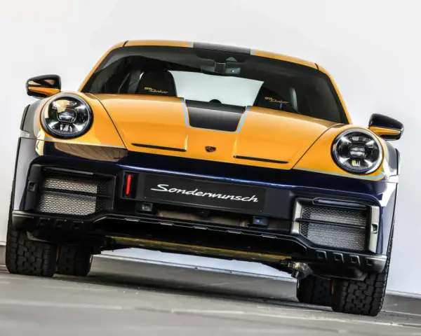 Żółto-granatowy Porsche 911 Dakar, gotowy na rajd dakar, z napisem "Sondermunsch" na zderzaku.