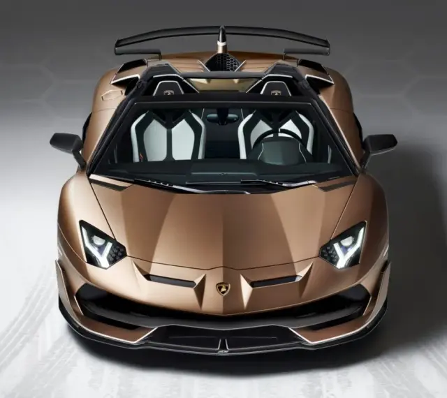 Brązowy Lamborghini Aventador SVJ z otwartym dachem, z czarnym spoilerem i białymi akcentami we wnętrzu, gotowy do jazdy.
