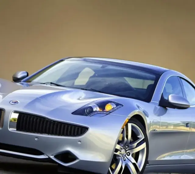 Srebrny Fisker Karma z eleganckimi liniami i sportowymi felgami, gotowy na podróż.