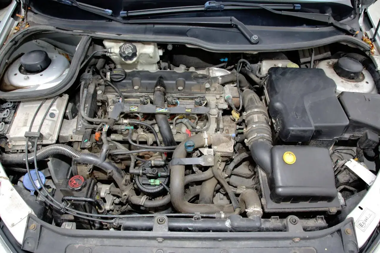 Silnik Peugeot 206 1.4 benzyna, widok z góry. Widać przewody, filtry i inne elementy jednostki napędowej.