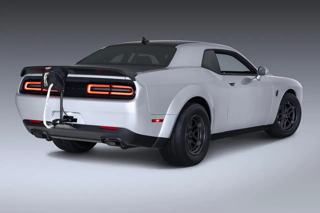 Srebrny Dodge Demon z czarnym spojlerem i przyczepionym workiem na tył.