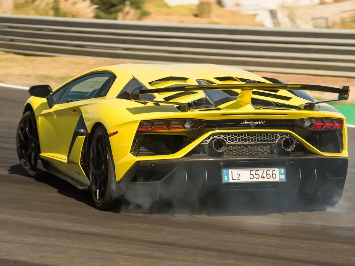 Żółty Lamborghini Aventador SVJ na torze, z dymem spod kół.