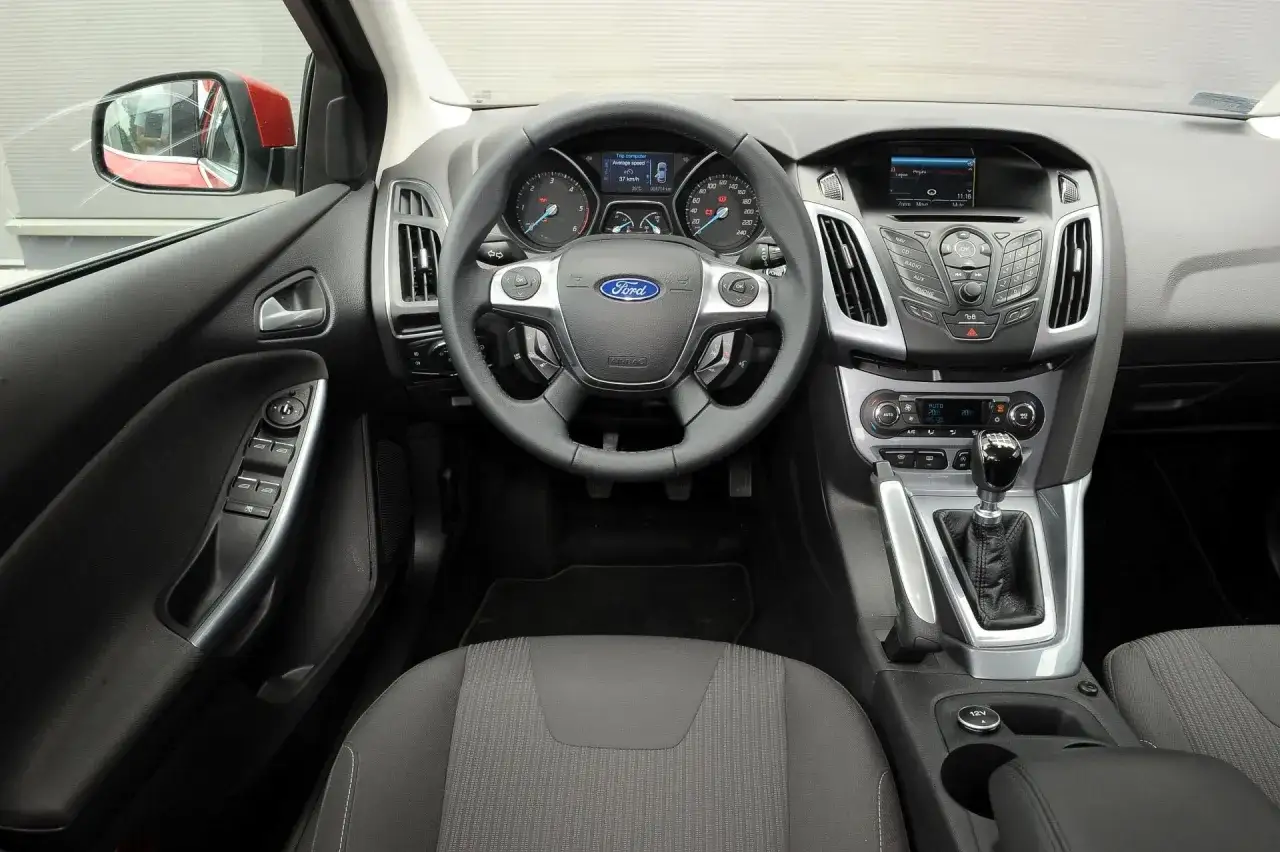 Wnętrze Ford Focus MK2 1.6 benzyna: kierownica, deska rozdzielcza z radiem i nawigacją, dźwignia zmiany biegów.