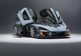 Niebieski McLaren Senna z otwartymi drzwiami, gotowy do startu.