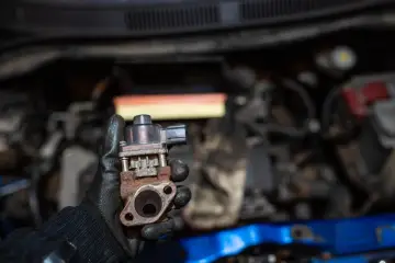 Zardzewiały zawór EGR w dłoni mechanika. Może to być przyczyna problemów z silnikiem, np. nierównej pracy.