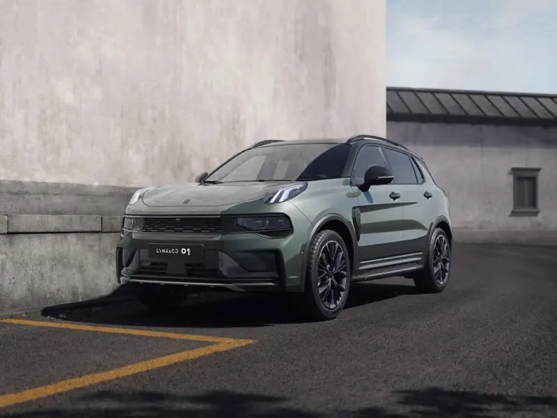 Nowoczesny, zielony SUV Lynk & Co 01 zaparkowany przy betonowej ścianie.