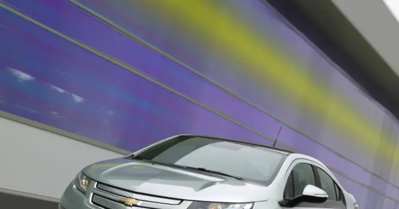 Srebrny Chevrolet Volt z nowoczesnym designem na tle tęczowej ściany.